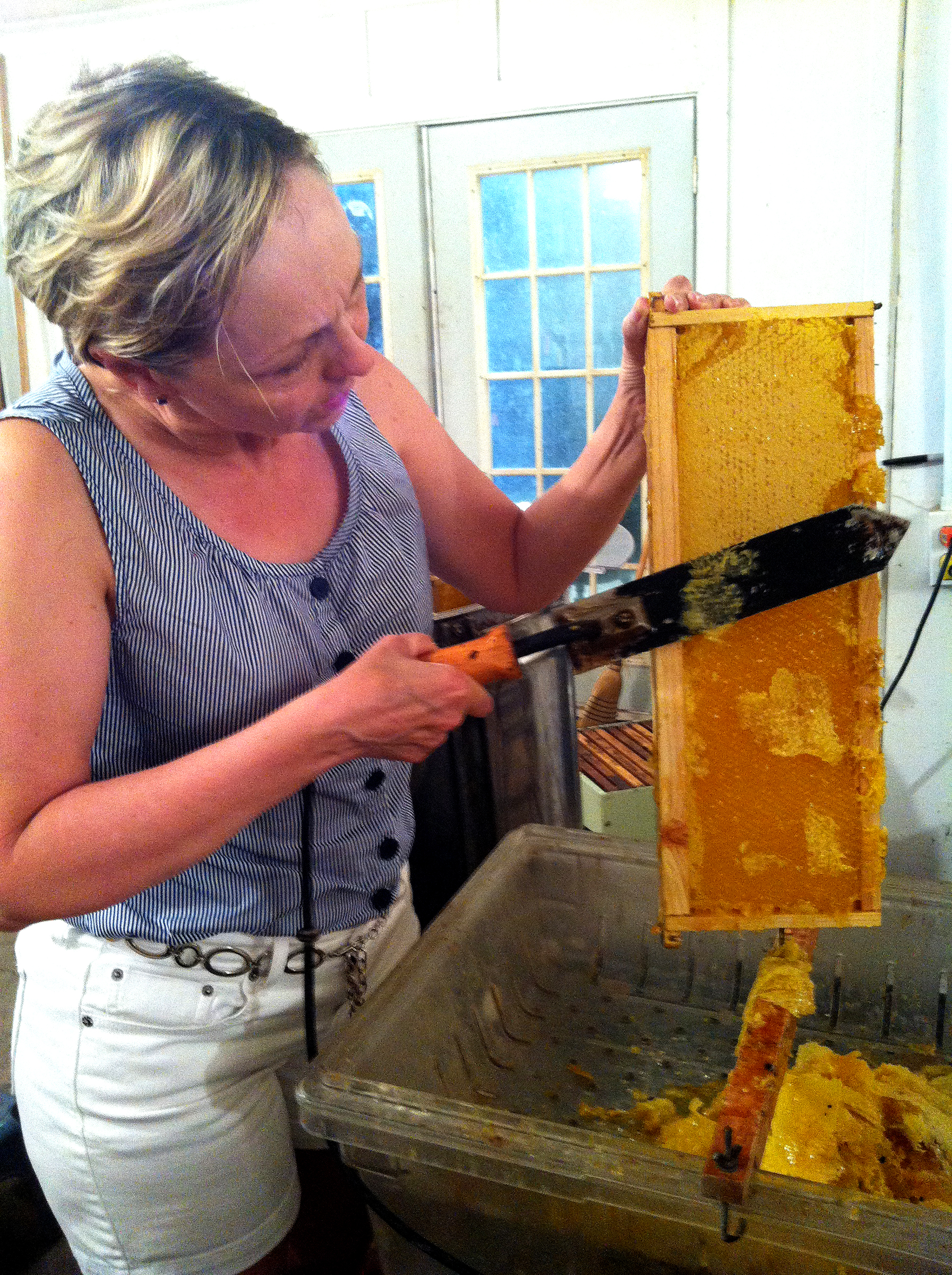 Rhonda takes her turn at cutting off the wax cappings.
